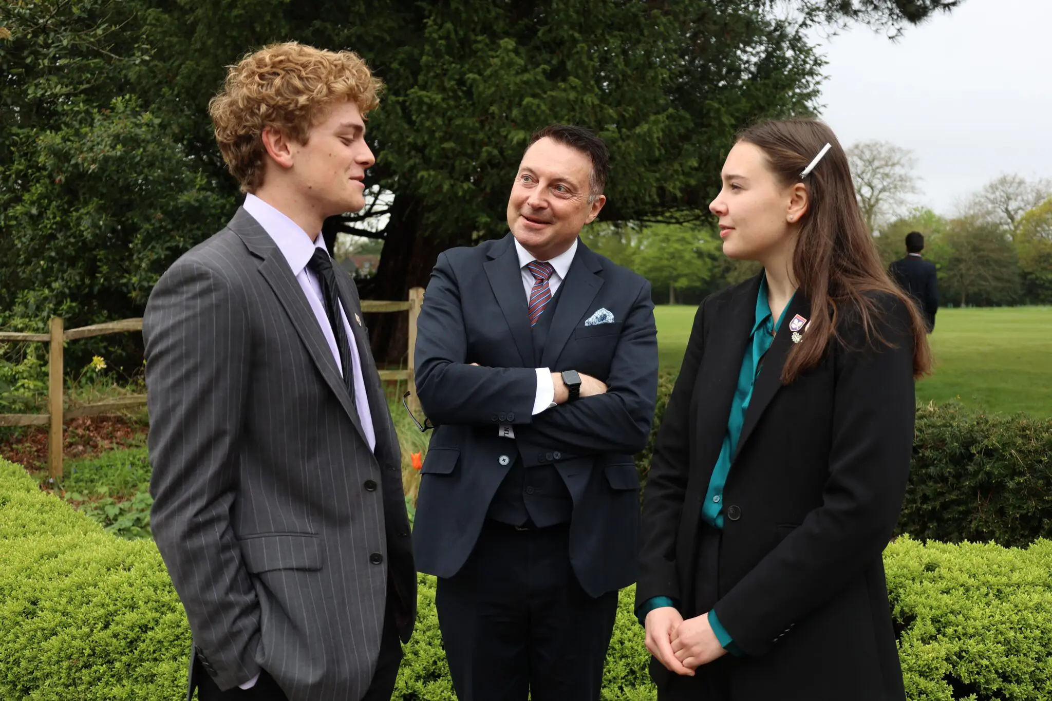 Teacher and students talking in the grounds of Leighton Park