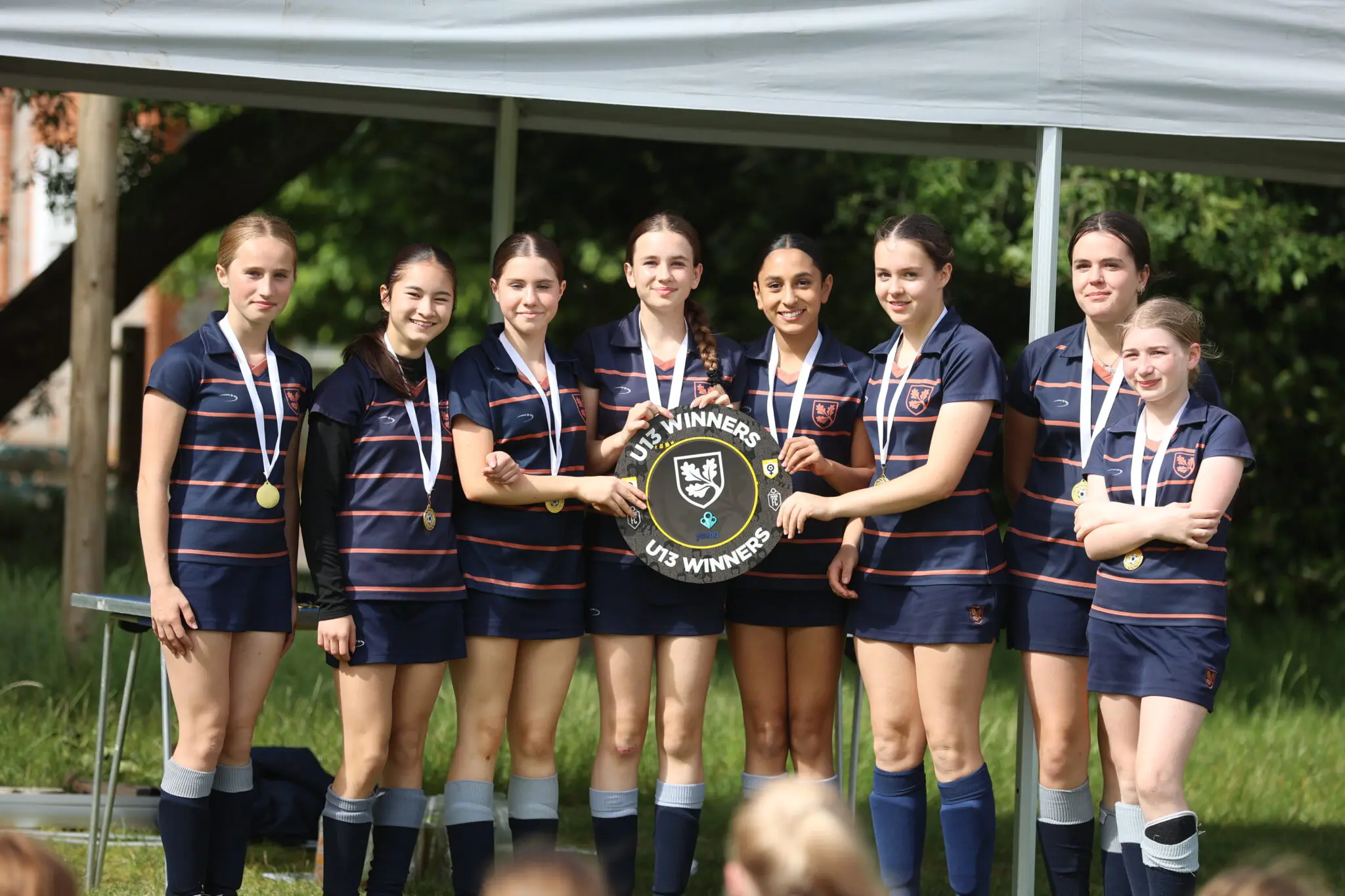 U13 girls sports team with trophy