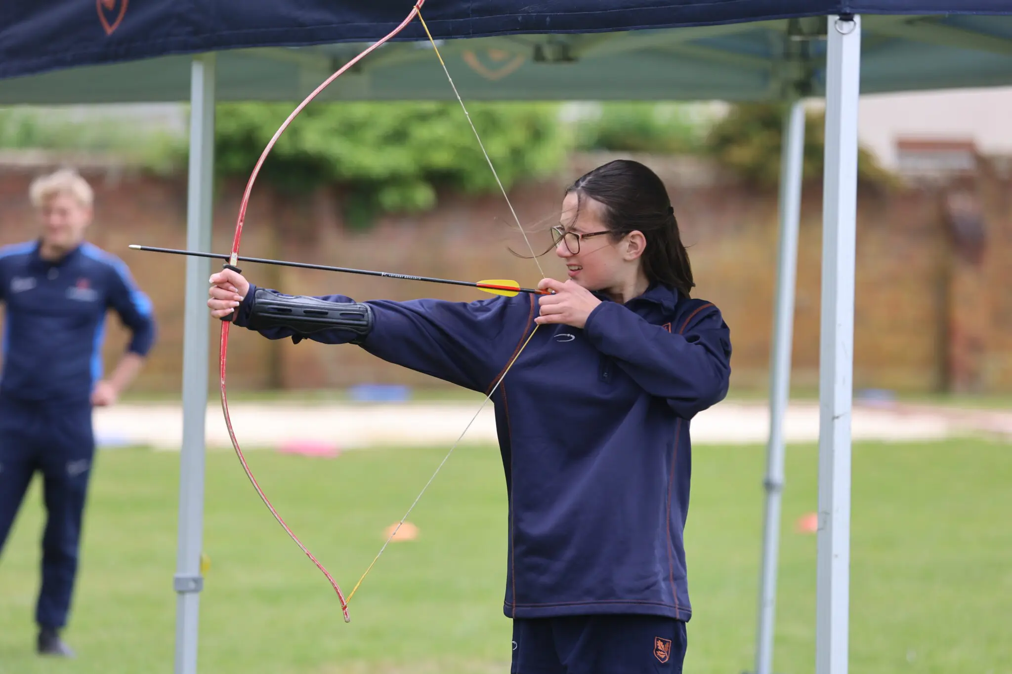 girl getting a lesson in archery