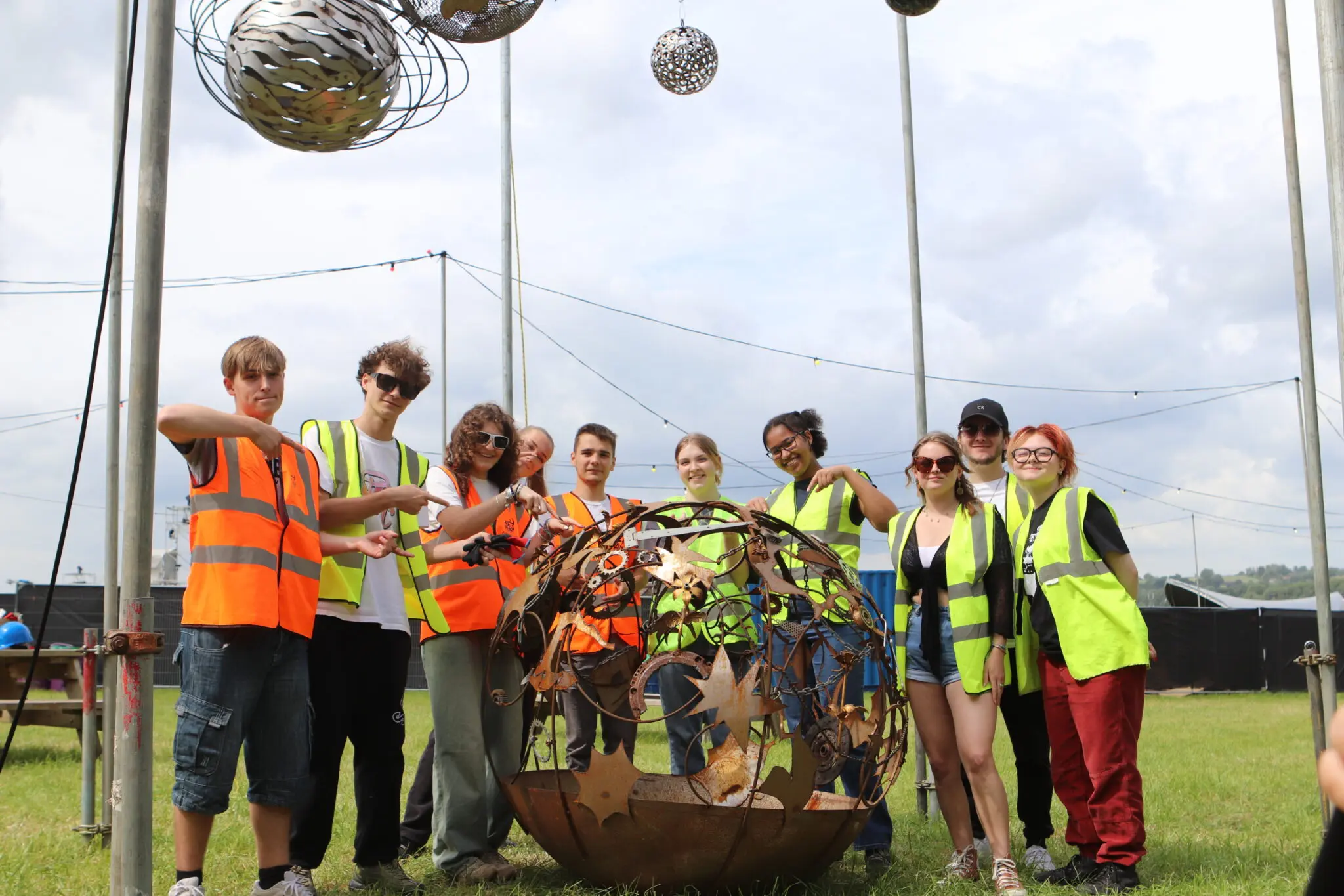 Sidcot Students pointing at their glastonbury festival art installation
