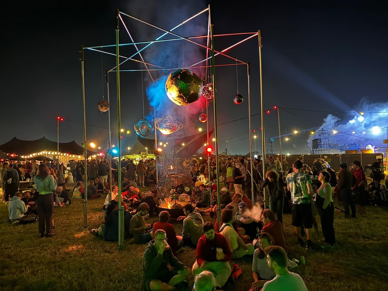 glastonbury festival art installation at night surrounted by people