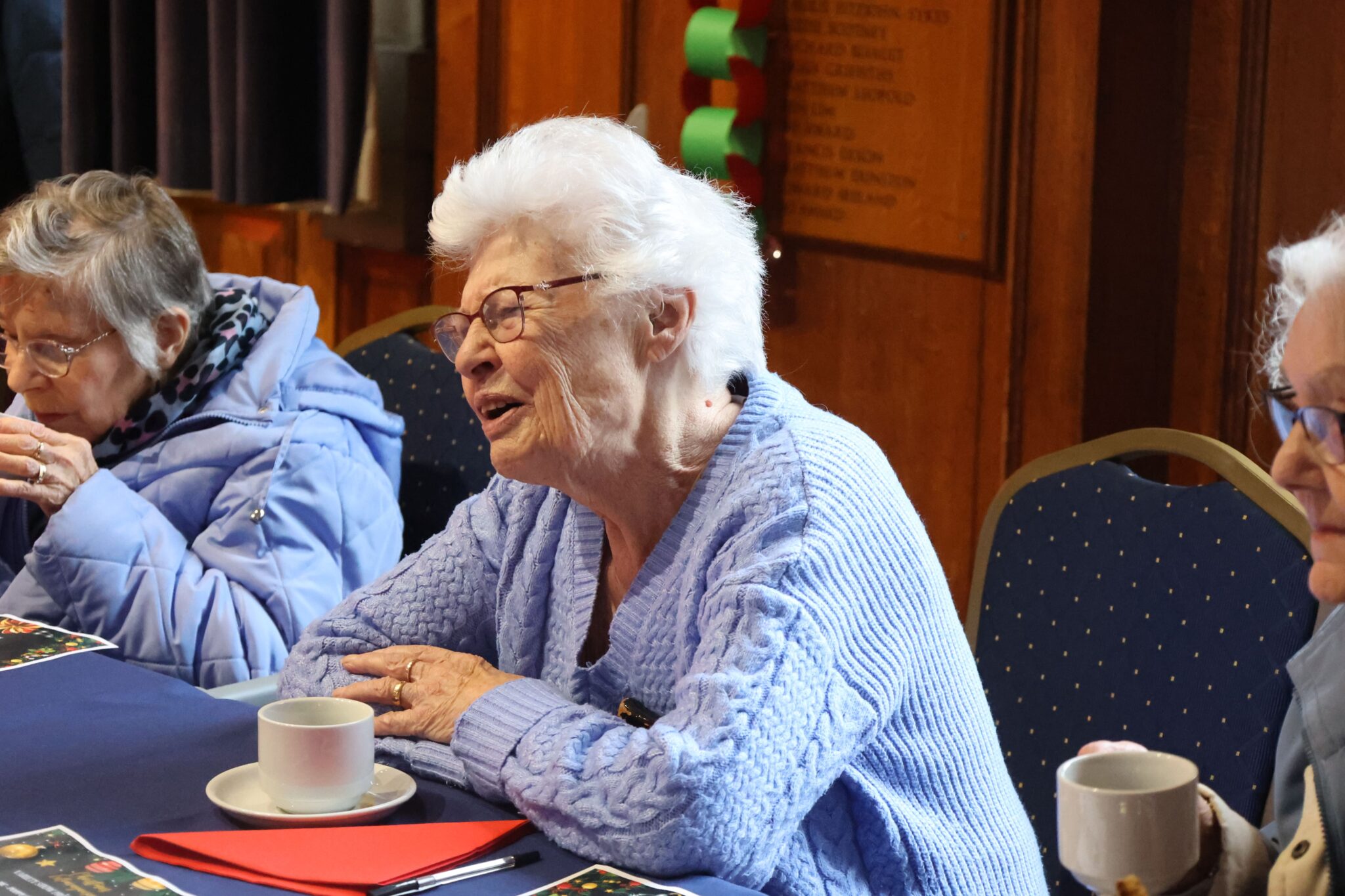 elderly woman talking at a Christmas dinner table