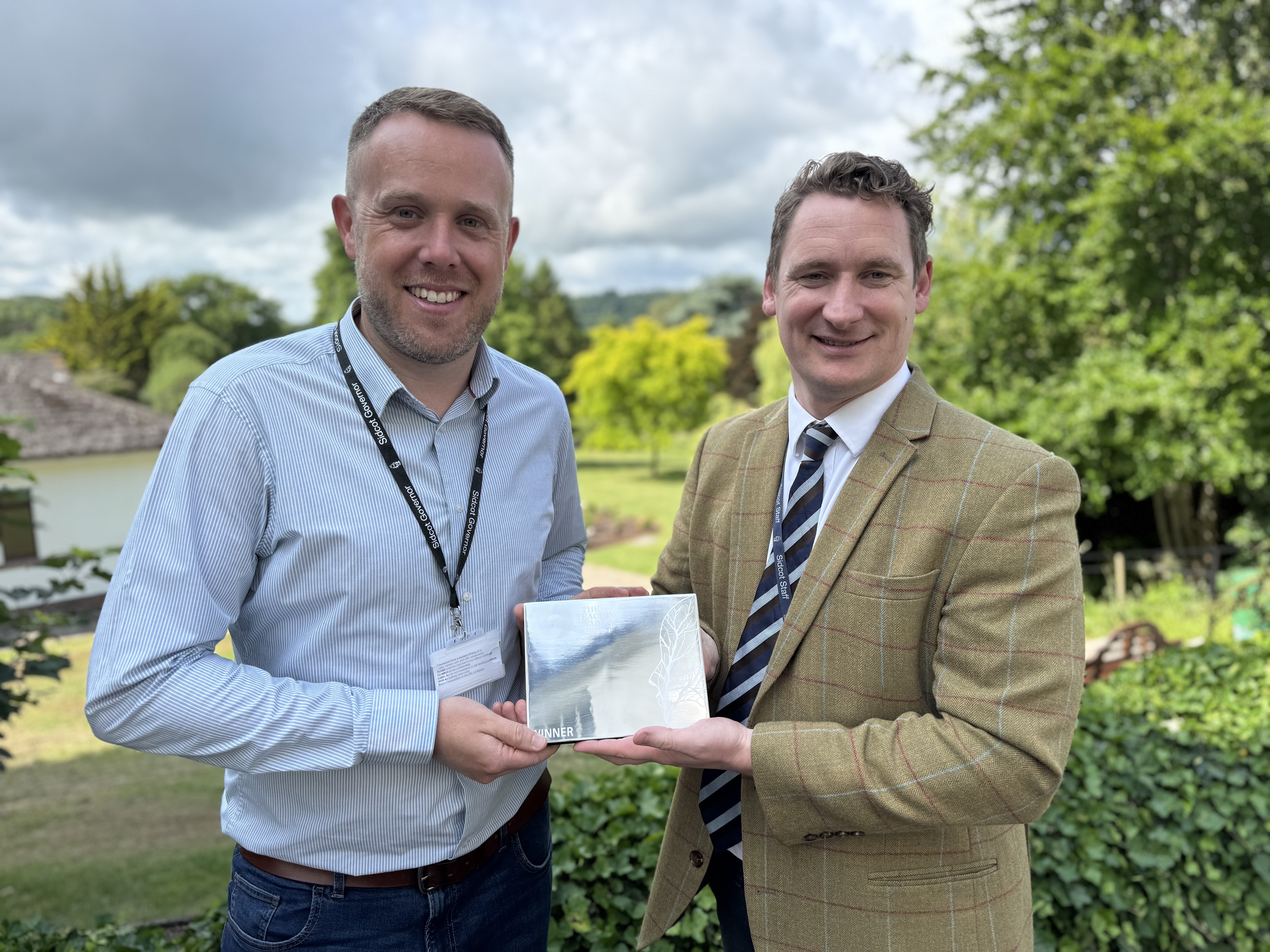 two men holding Pearson National Teaching Award 