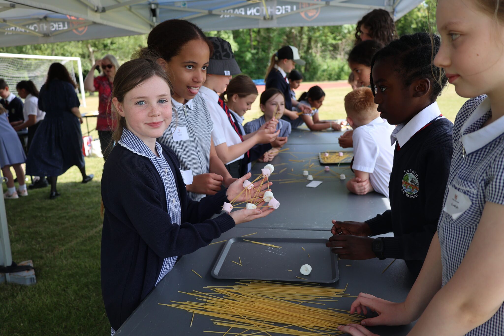 school kids making things out of spaghetti and marshmallows