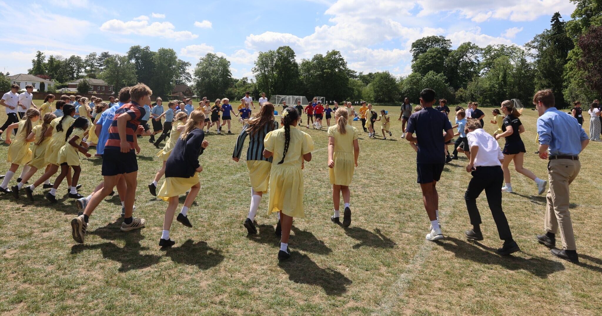 school children running on a field