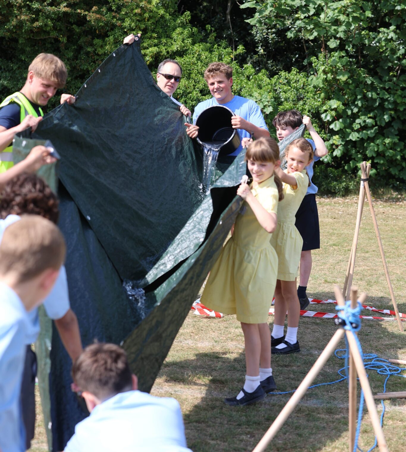 children holding tarp with running water