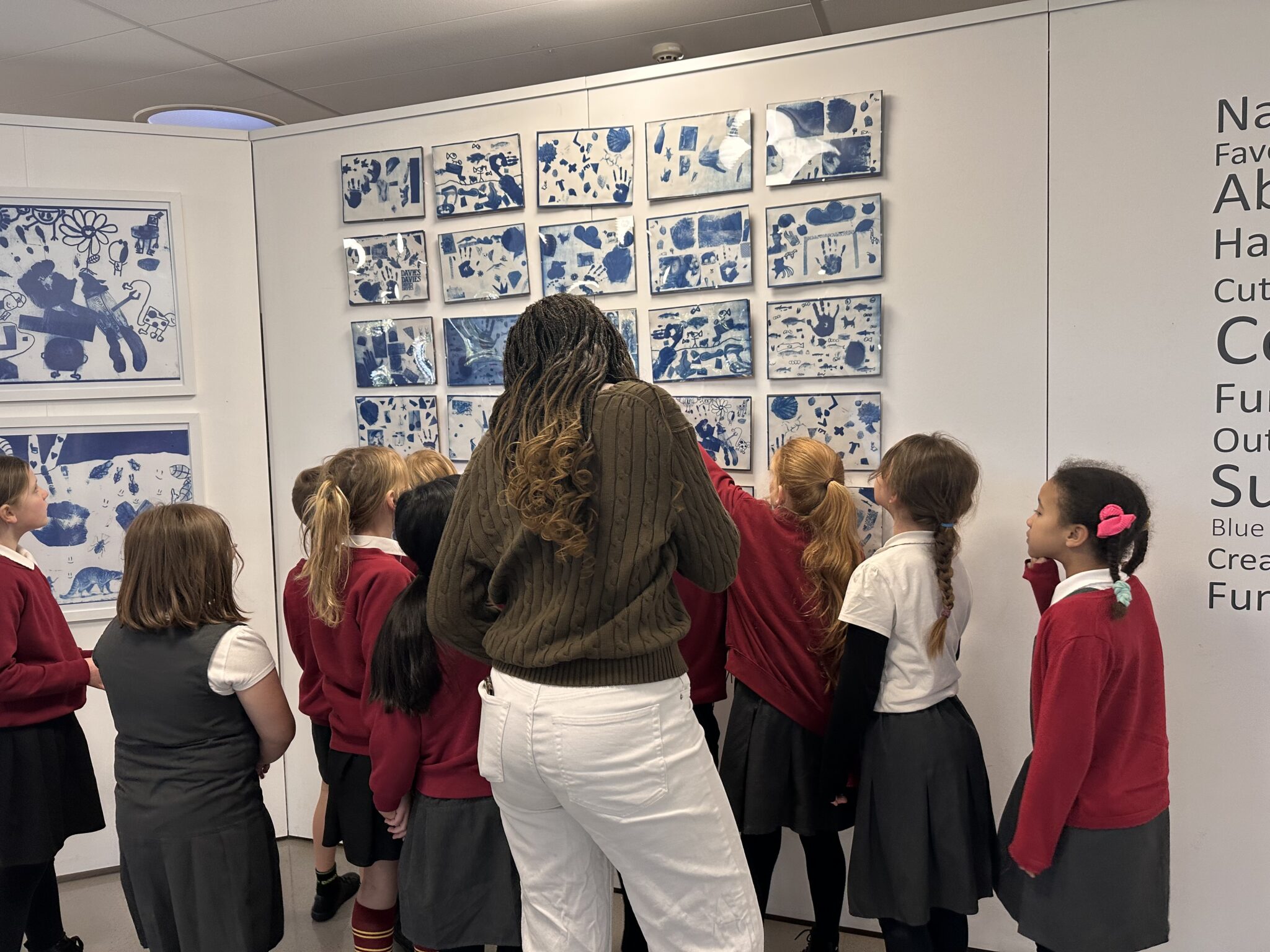 children looking at their artwork in a gallery