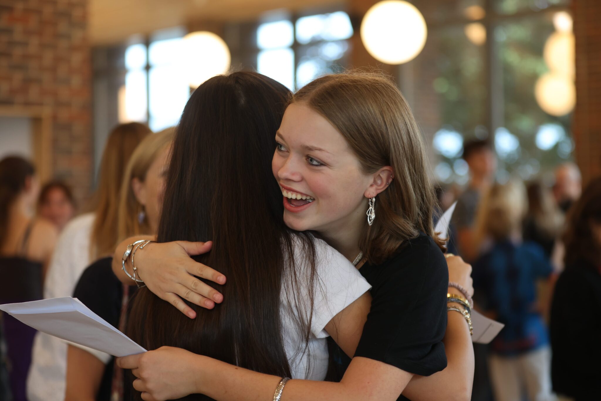 girls hugging to celebrate GCSE results