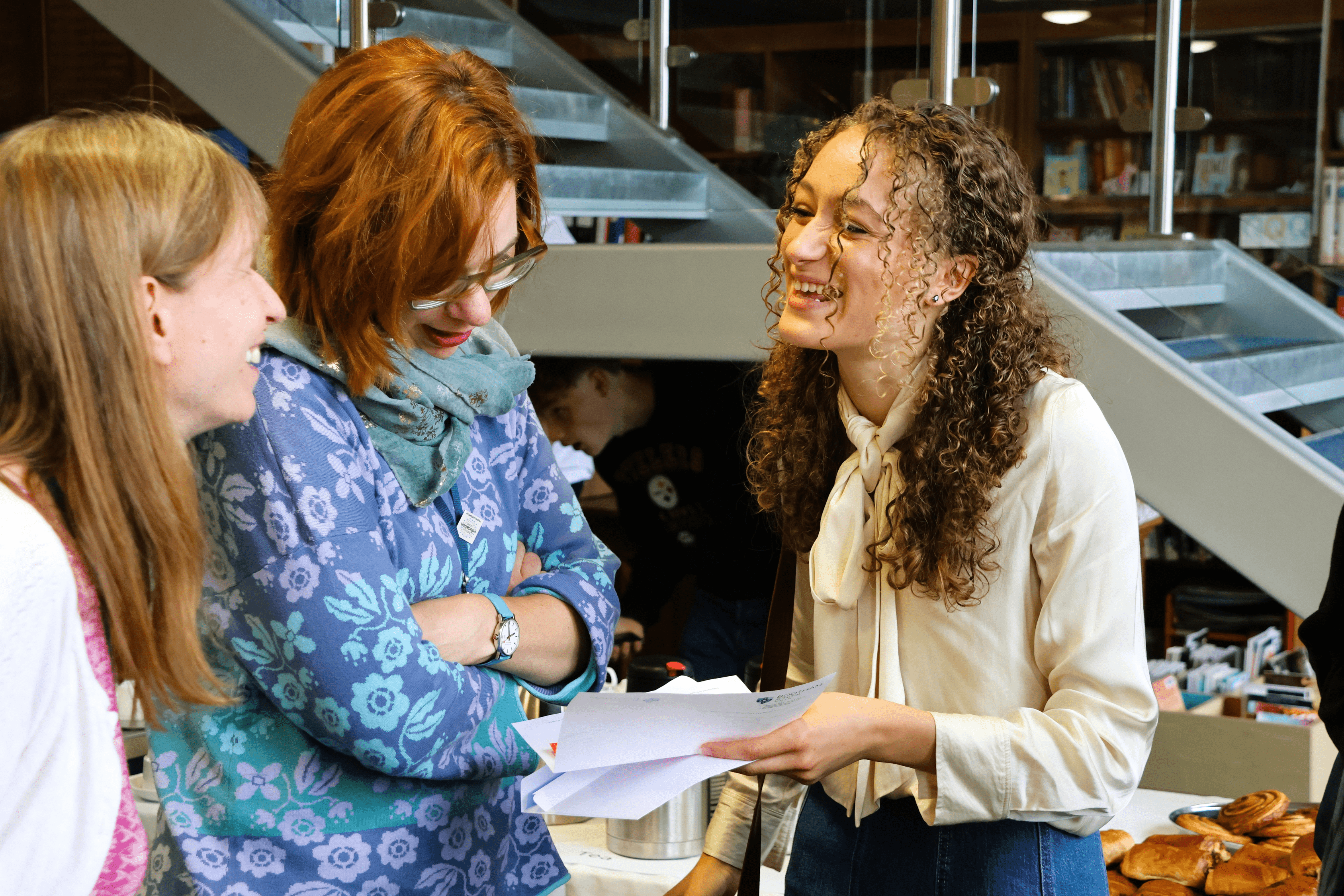 Student laughing with teachers on GCSE results day 2025