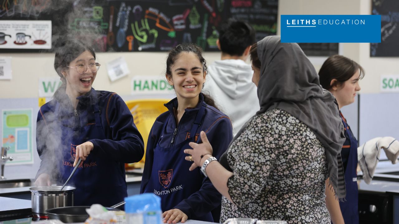girls laughing with culinary school tutor